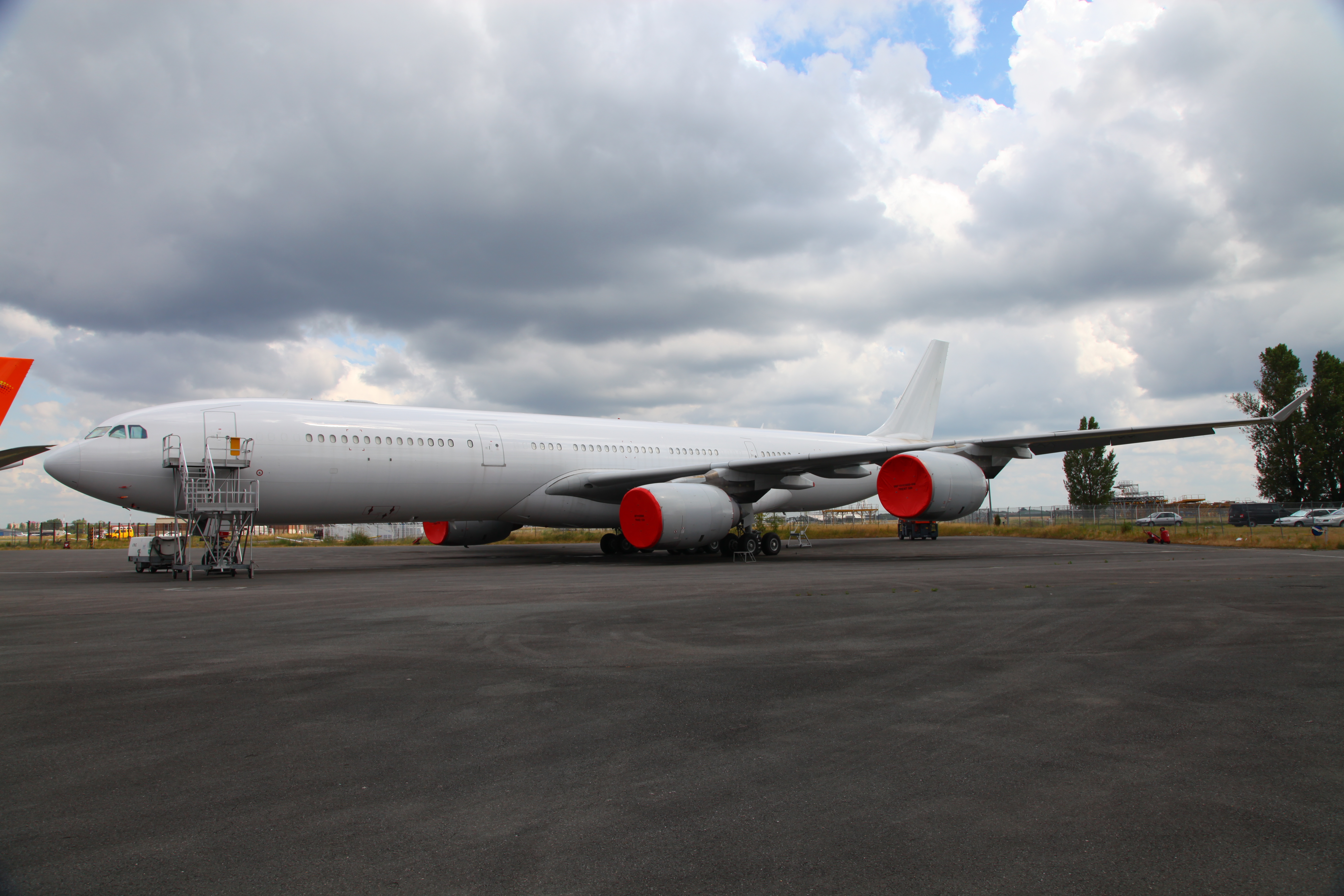 Wide-body jet aircraft parked on tarmac with engine covers — IAS aircraft ferry and storage services worldwide